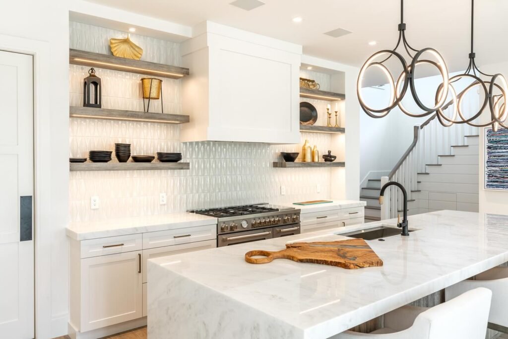 Modern white shaker cabinets with marble waterfall island, textured backsplash, floating wood shelves, and contemporary pendant lighting in kitchen remodel Salt Lake City