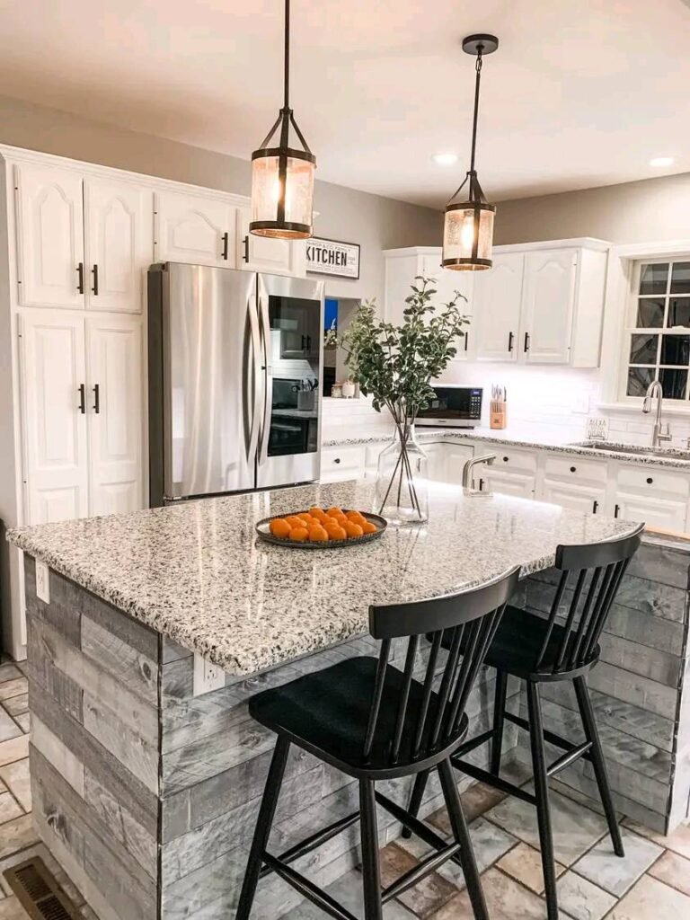Modern white shaker cabinets with large granite waterfall island, rustic wood base, black bar stools, stainless appliances, and pendant lighting in kitchen remodel Salt Lake City