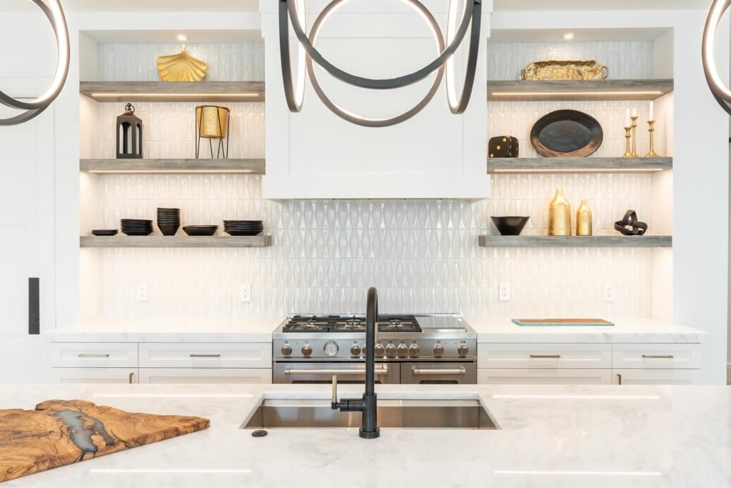 Modern open-concept kitchen with large marble waterfall island, wood lower cabinets, black fixtures, and pendant lighting in kitchen remodel Salt Lake City